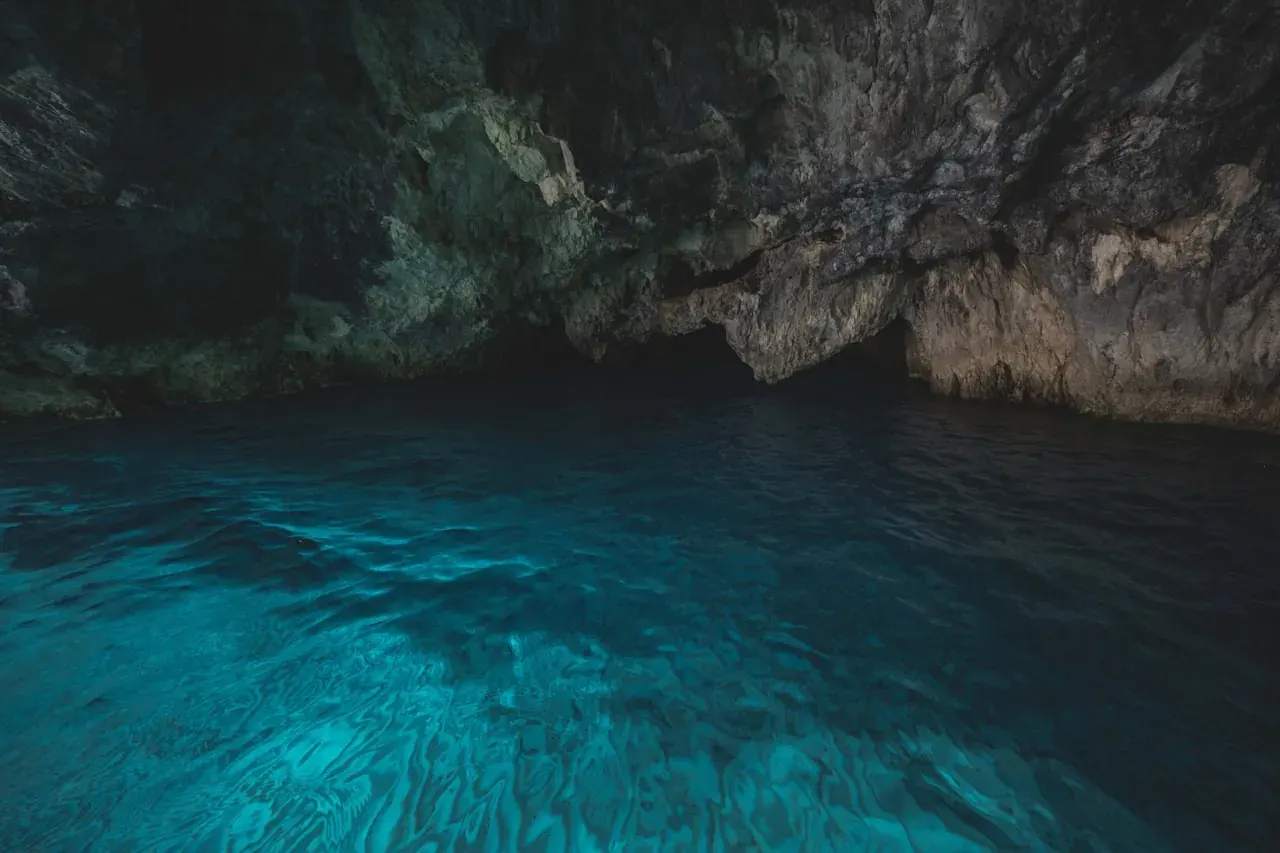 Cenote Xkeken near Valladolid, an underground cave cenote with stalactites hanging from the ceiling over turquoise water