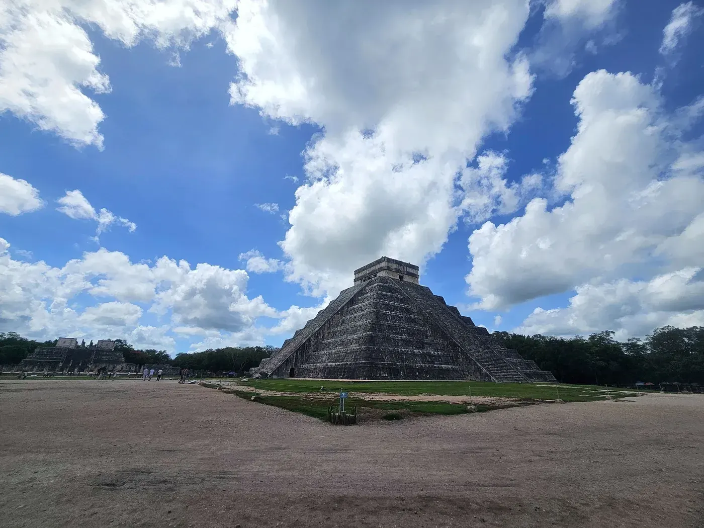 Wide view of El Castillo pyramid at Chichen Itza with dramatic clouds