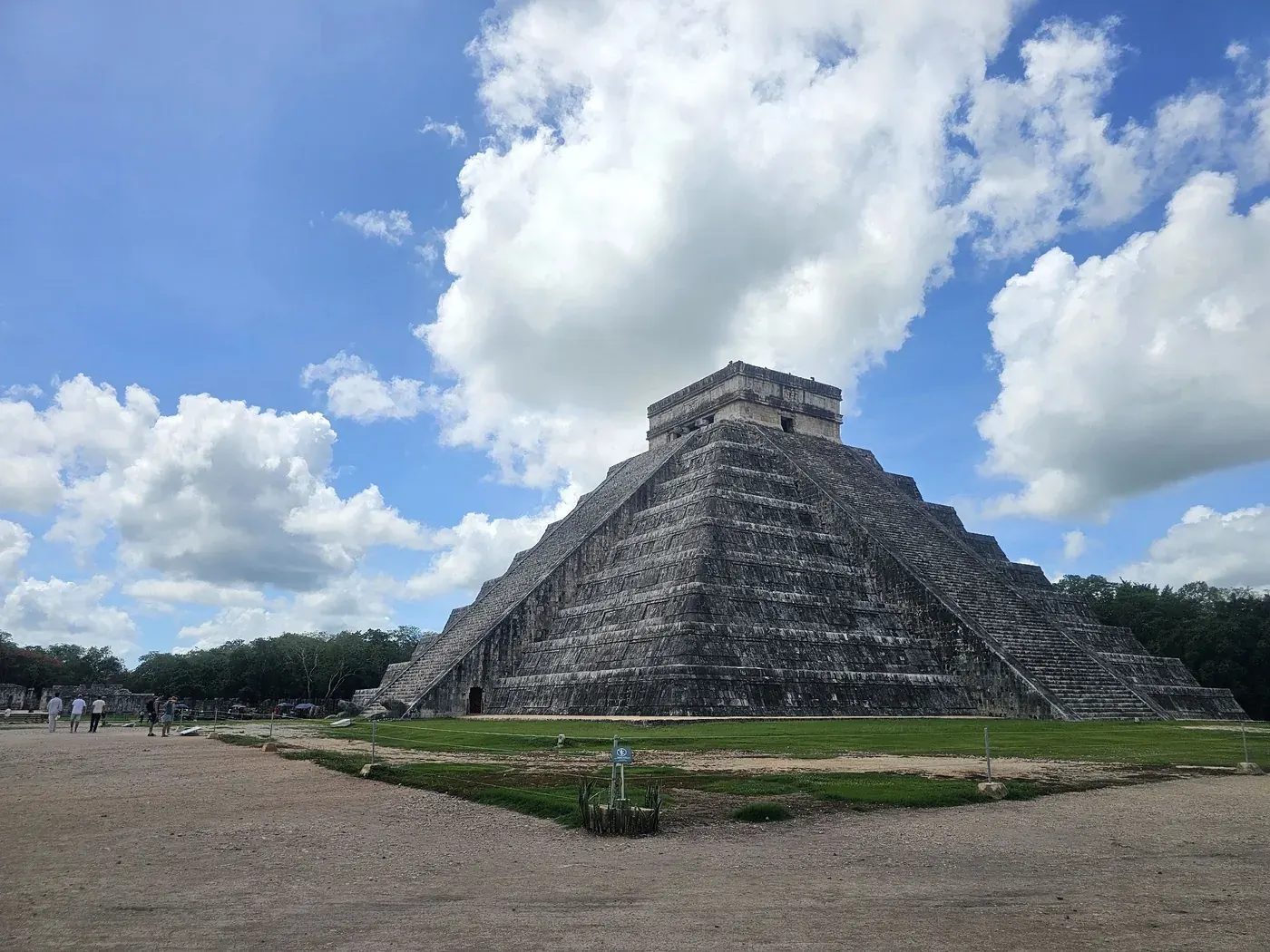 El Castillo pyramid at Chichen Itza with white clouds above the ruins