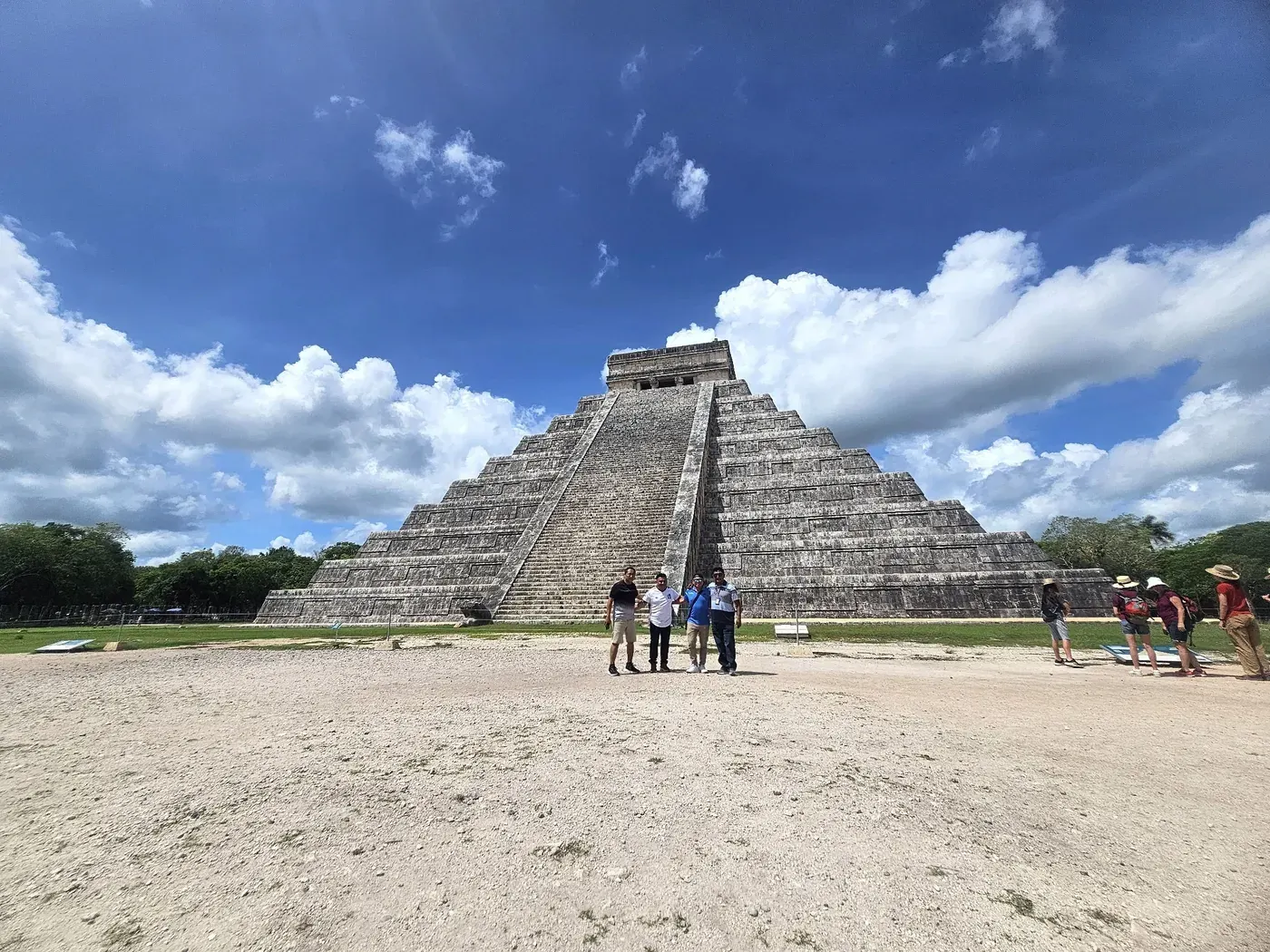 Travelers posing in front of El Castillo pyramid during a Chichen Itza tour